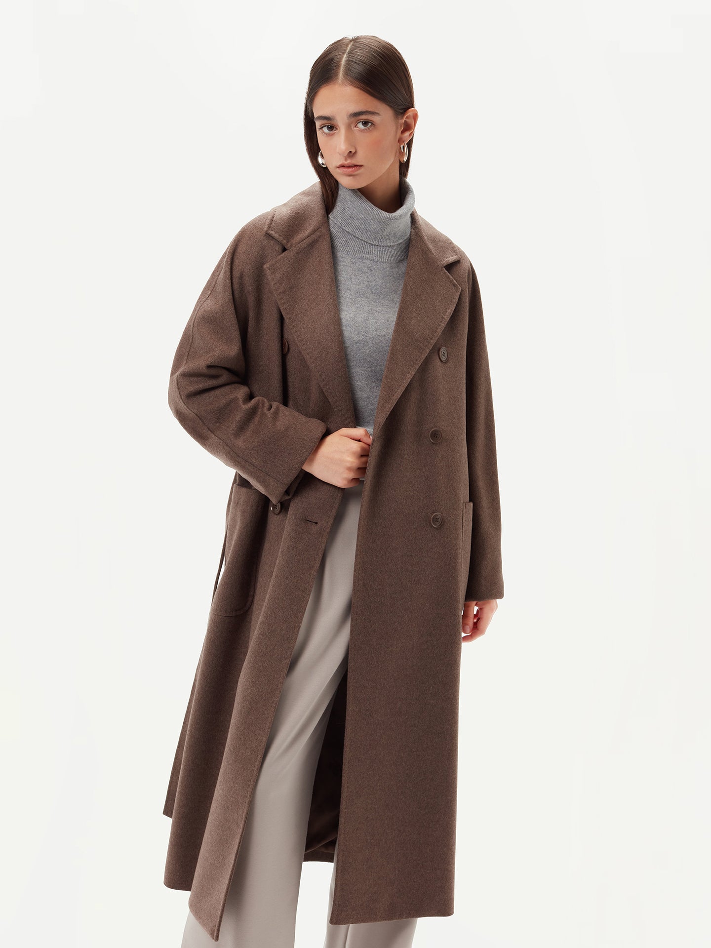 A model wearing a warm brown cashmere coat, styled with a belted waist for an elegant and cozy look.