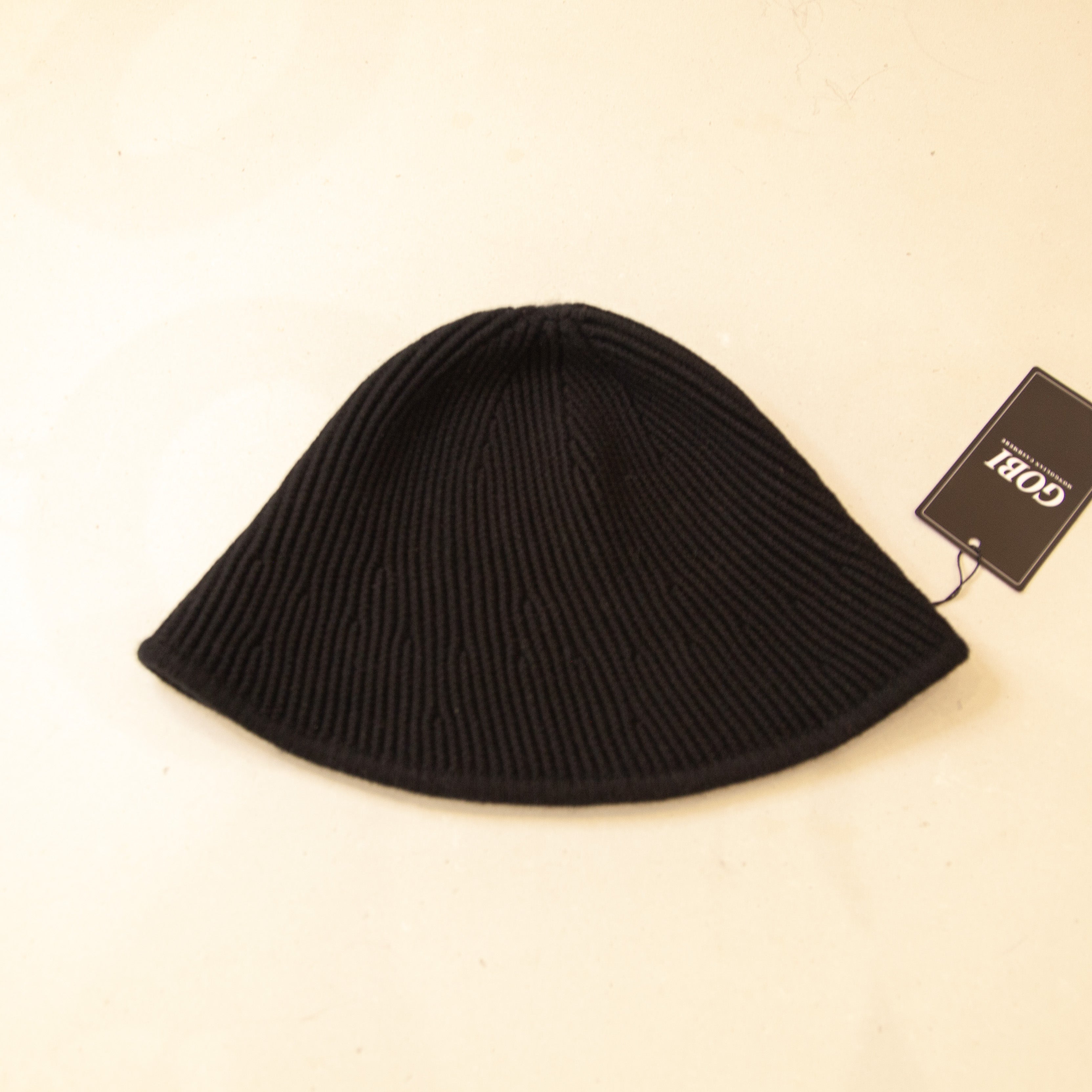 Flat lay of black cashmere bucket hat, featuring a soft texture and stylish, versatile design.