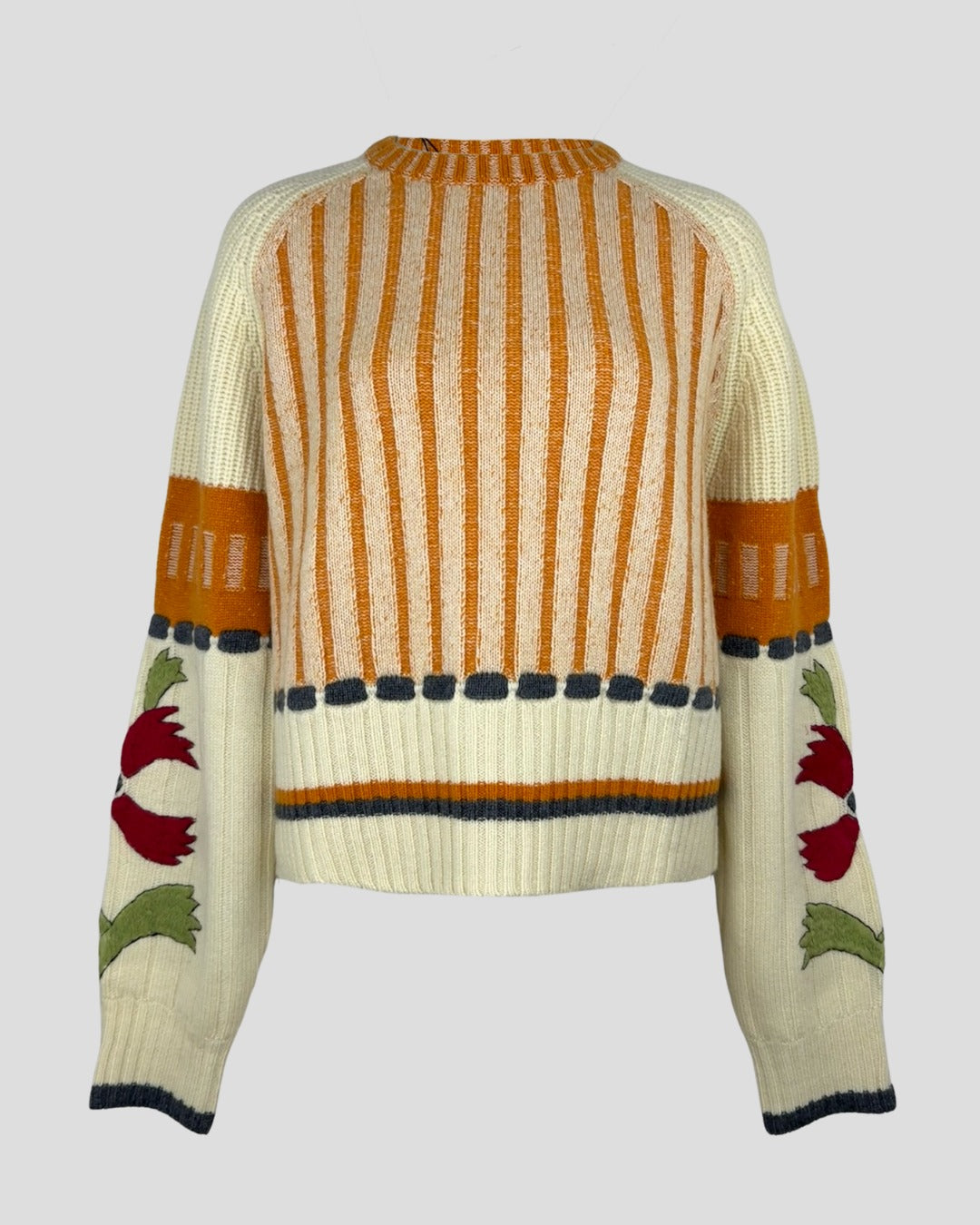 An elegant cashmere sweater in orange and cream color with embroidery.