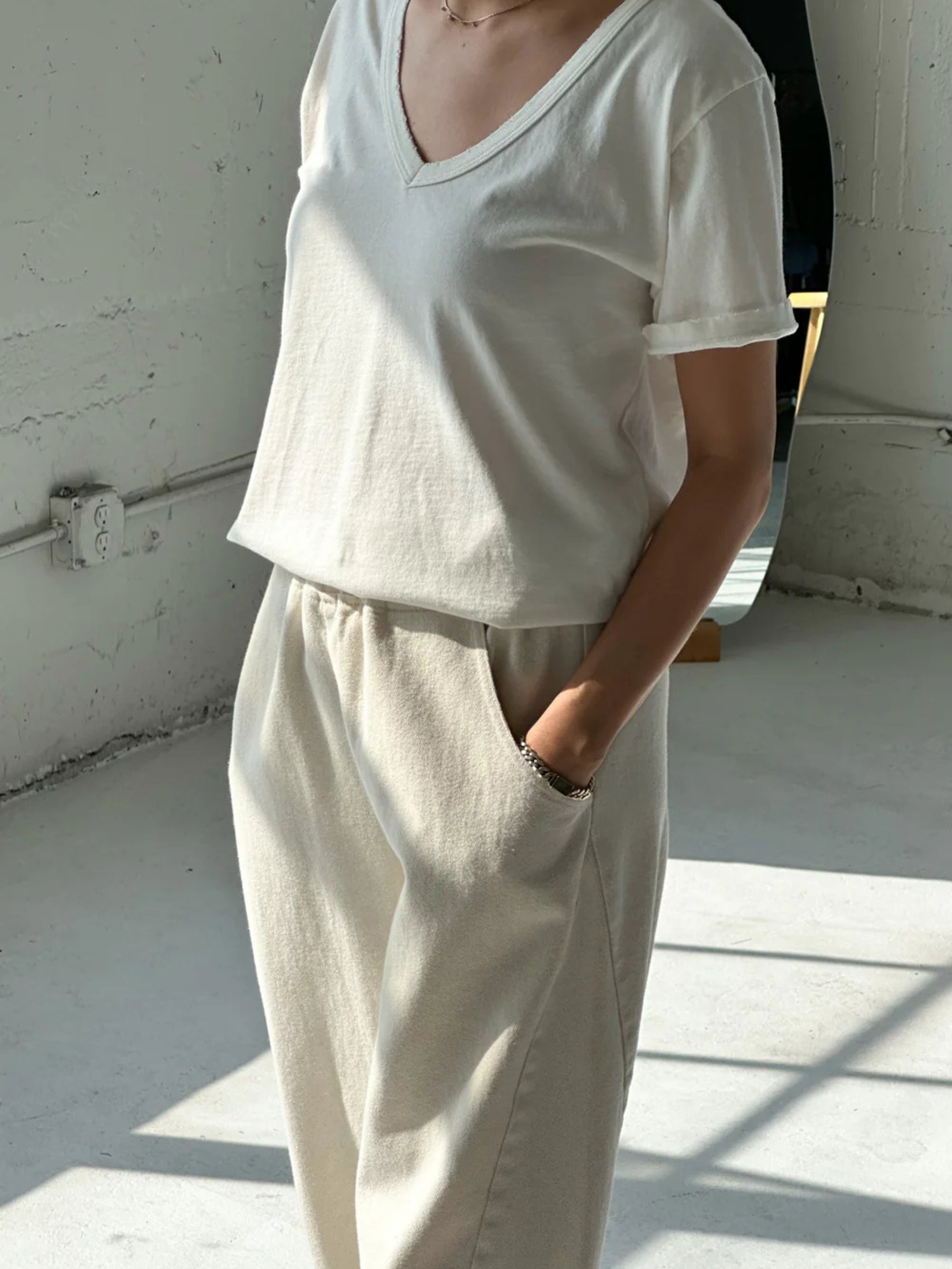 Model wearing a white cotton La Vie V-neck tee with a relaxed fit.