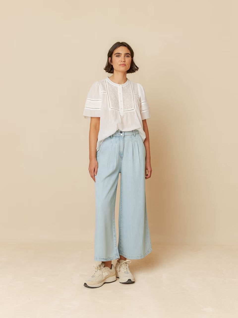 A model wearing lyocell denim pants, featuring a relaxed fit and washed denim effect for a casual, stylish look.