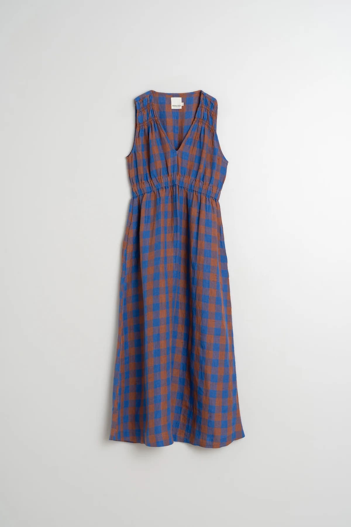 Flat lay of a long azul checkered dress made from a cotton-linen blend.