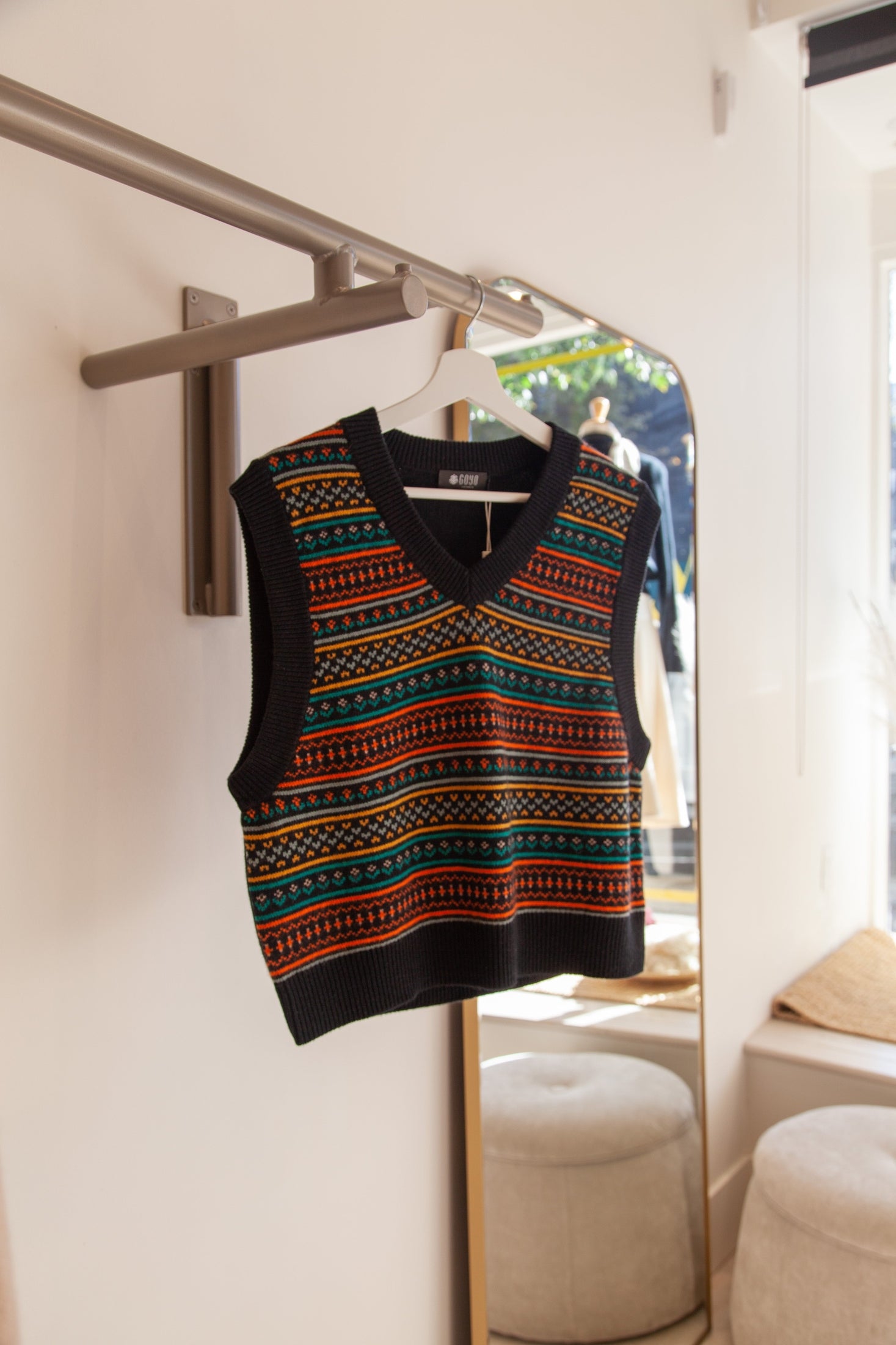 Black cashmere boho-chic vest on hanger, featuring a relaxed design and soft, luxurious texture.