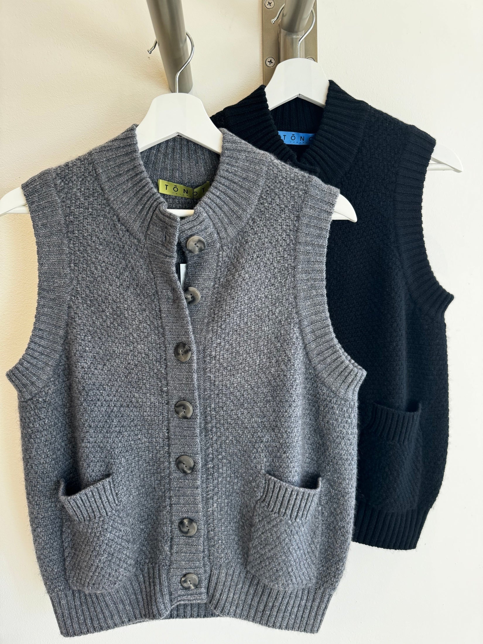 Black and grey moss stitch cashmere button vests.