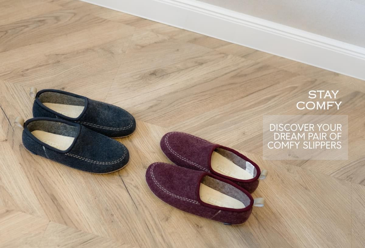 navy and brown felt slippers, highlighting their soft material and comfortable, casual design.