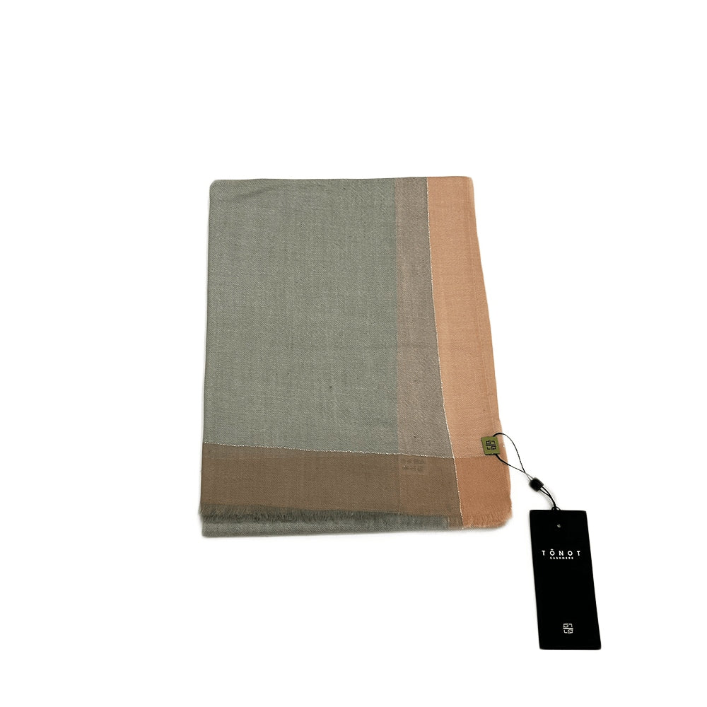 Green fine cashmere shawl, folded, showcasing its soft texture and elegant, refined look.