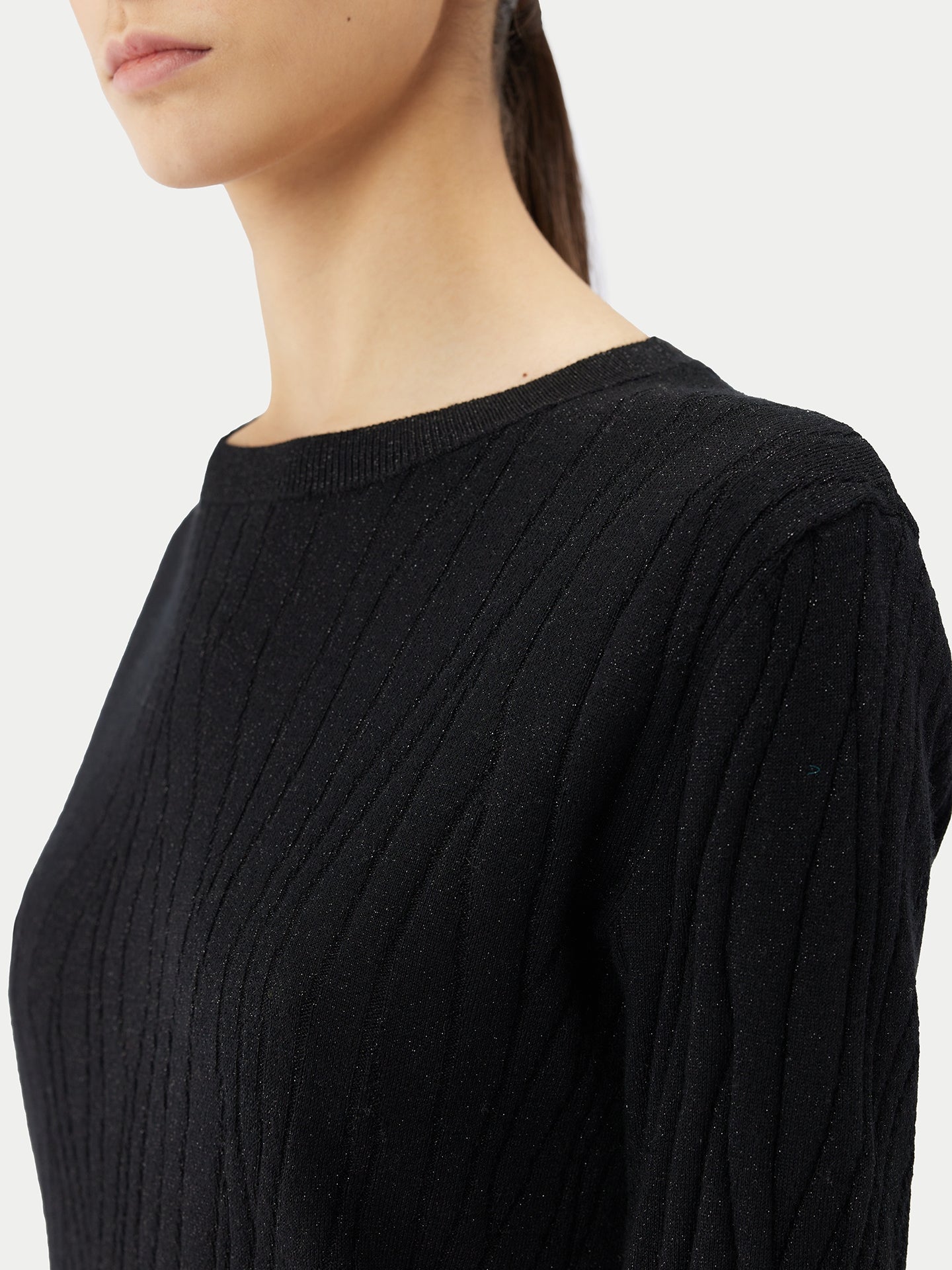 A model wearing a stylish black sweater made from a luxurious blend of silk, cashmere, with silver thread.