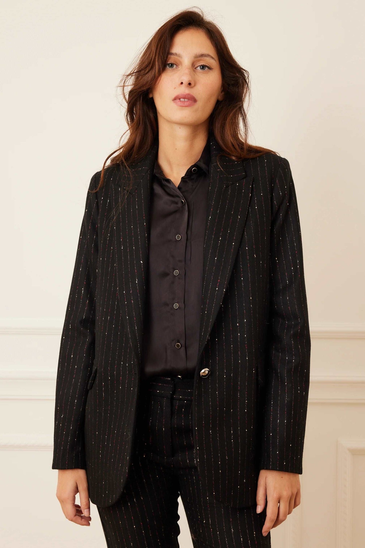 Model wearing a black stripe wool blazer set