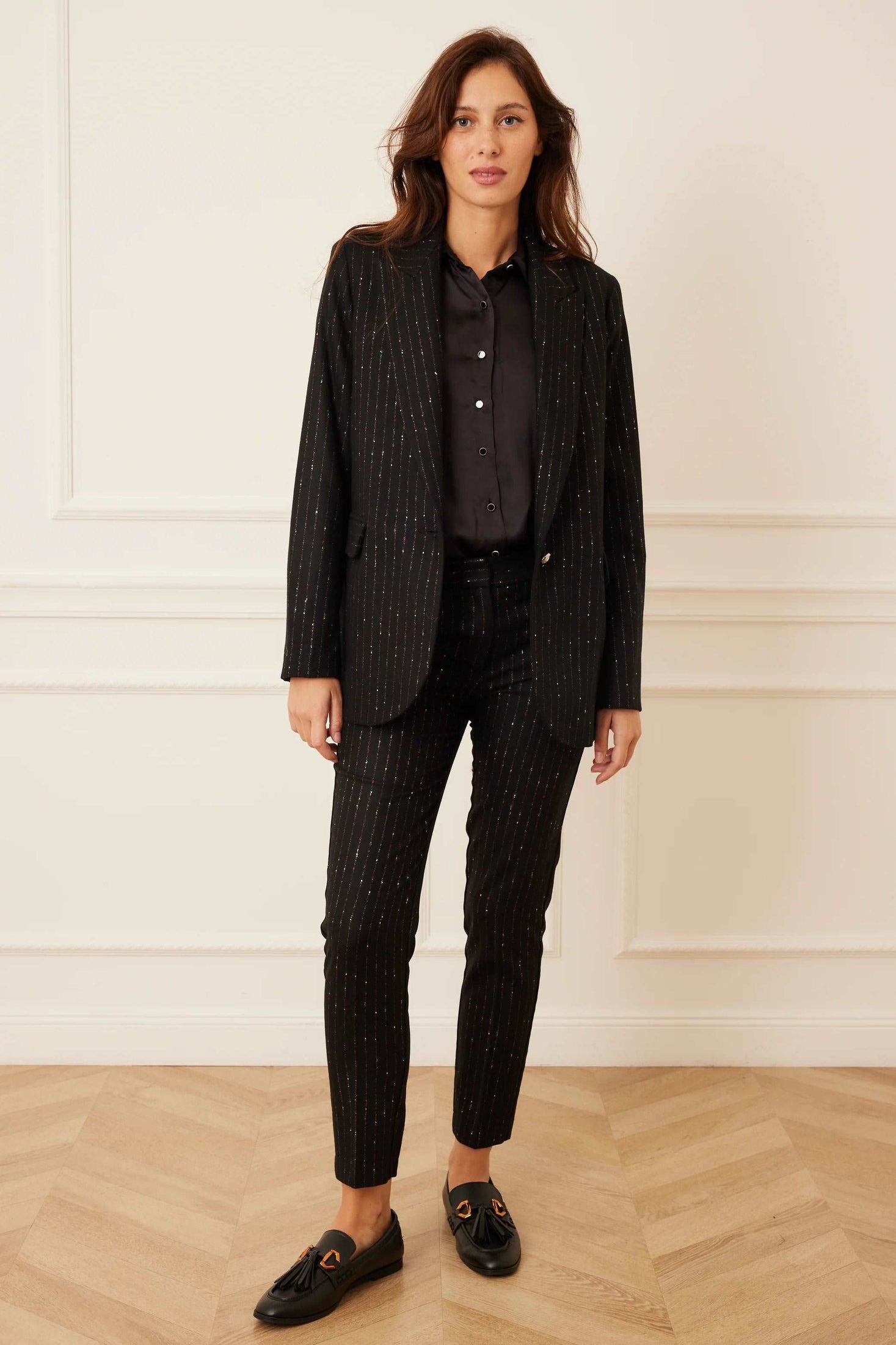 Model wearing a black stripe wool blazer set