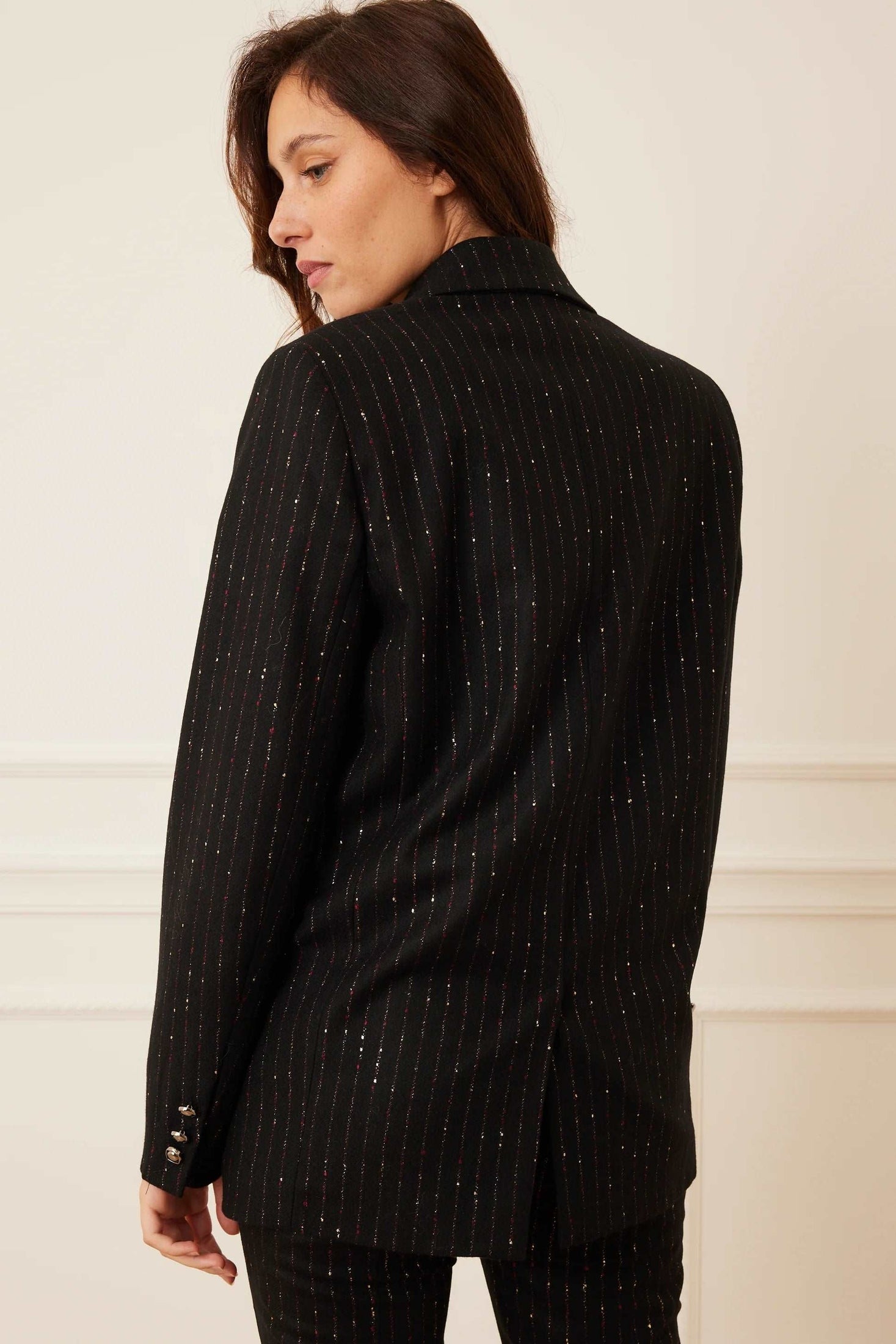 Back view of a model wearing a black stripe wool blazer.