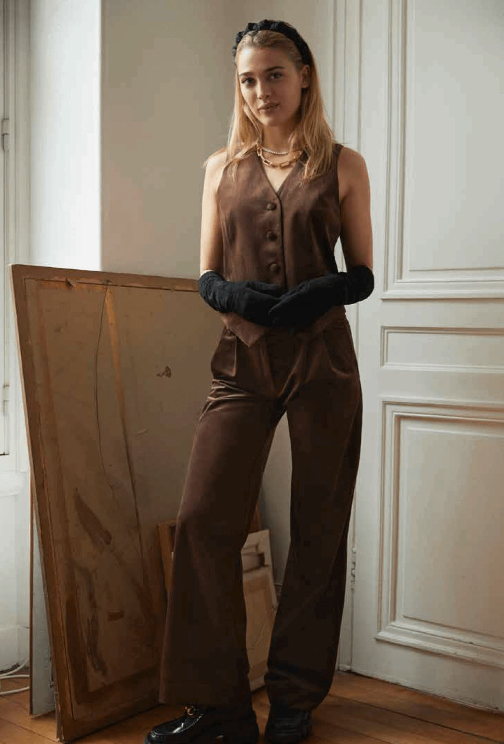 Model wearing a brown velour pants and vest set.