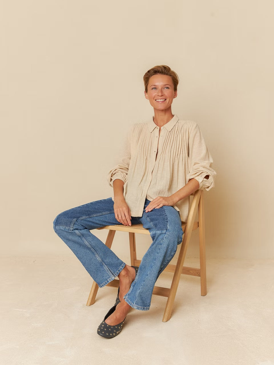 A model wearing a beige cotton shirt, showcasing a simple and timeless design with a comfortable fit.