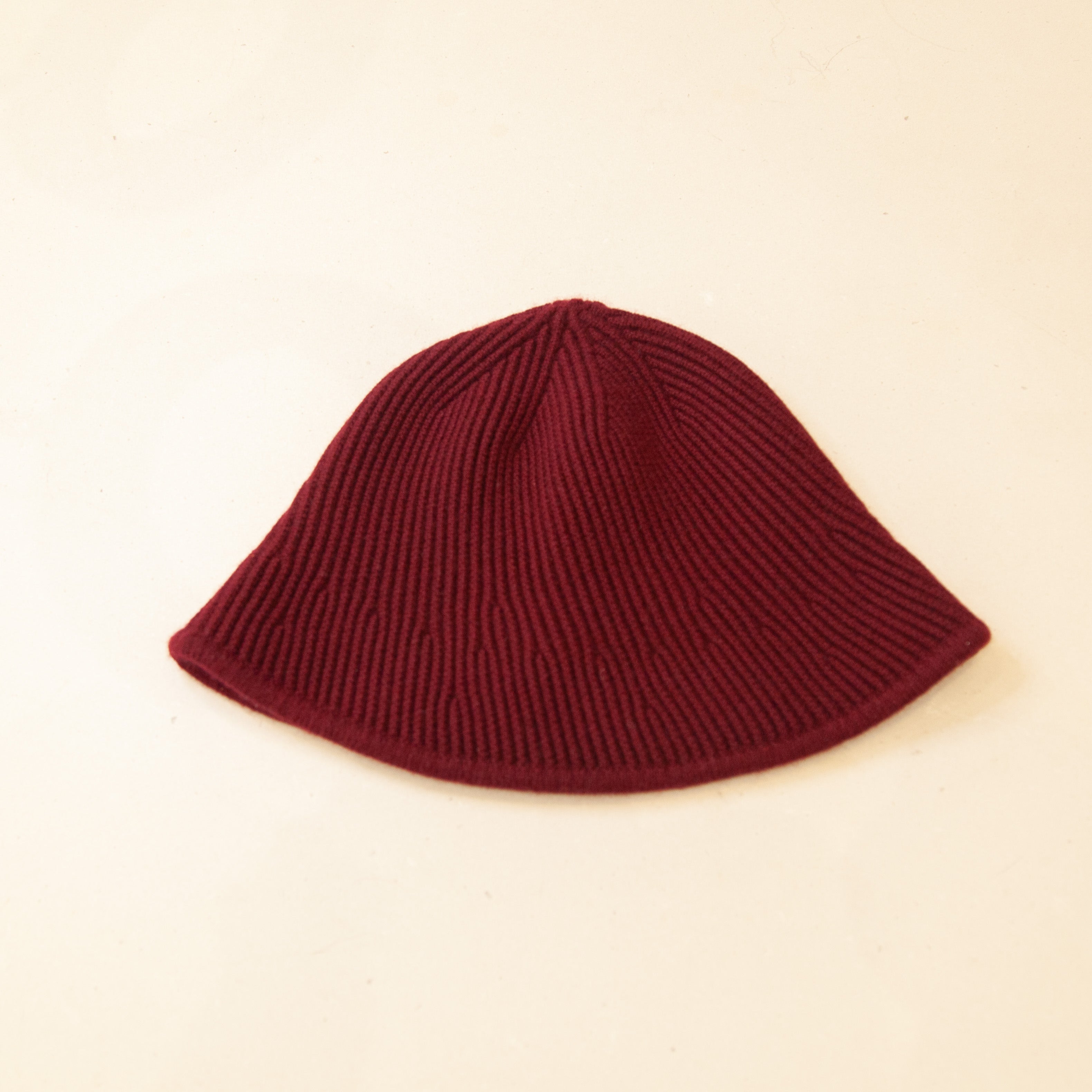 Flat lay of red cashmere bucket hat, featuring a soft texture and stylish, versatile design.