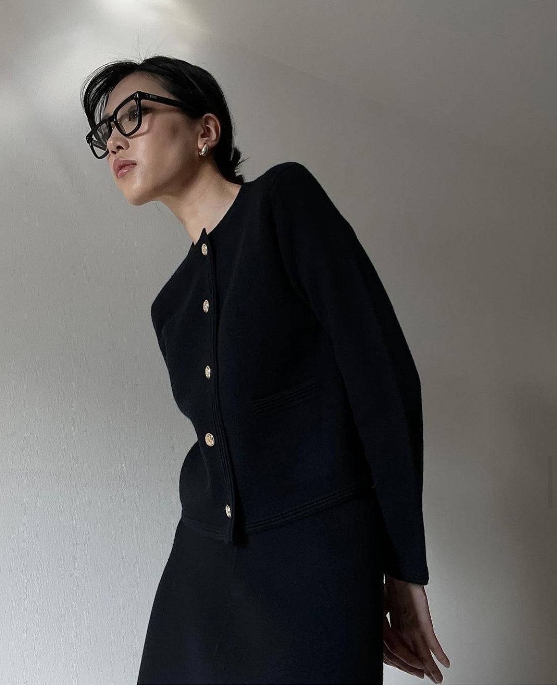 Black cashmere blazer set worn by model with skirt, featuring a tailored fit and elegant, sophisticated style.