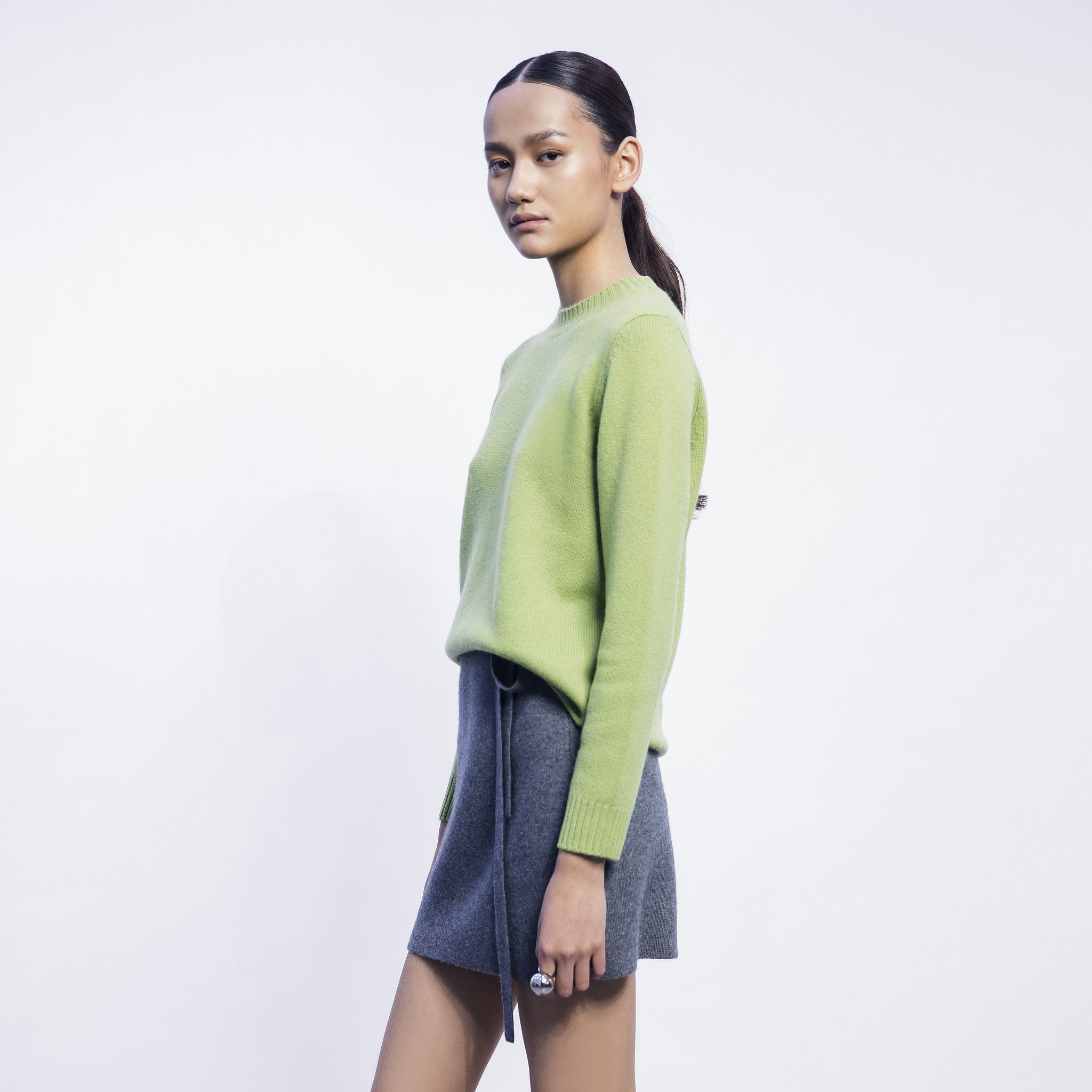 Model wearing lime cashmere sweater, showcasing a vibrant color and soft, luxurious texture with a comfortable, relaxed fit.