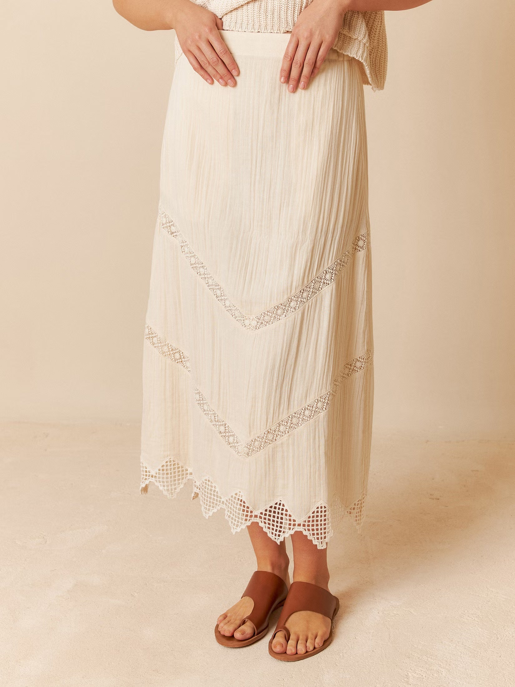 Model wearing a cotton skirt with crochet details, showcasing a relaxed fit.