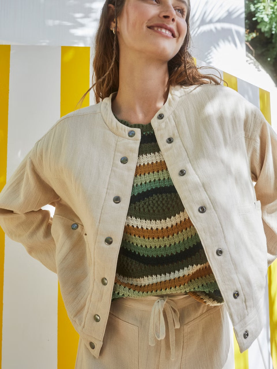 Model wearing an ecru organic cotton jacket with a relaxed fit.