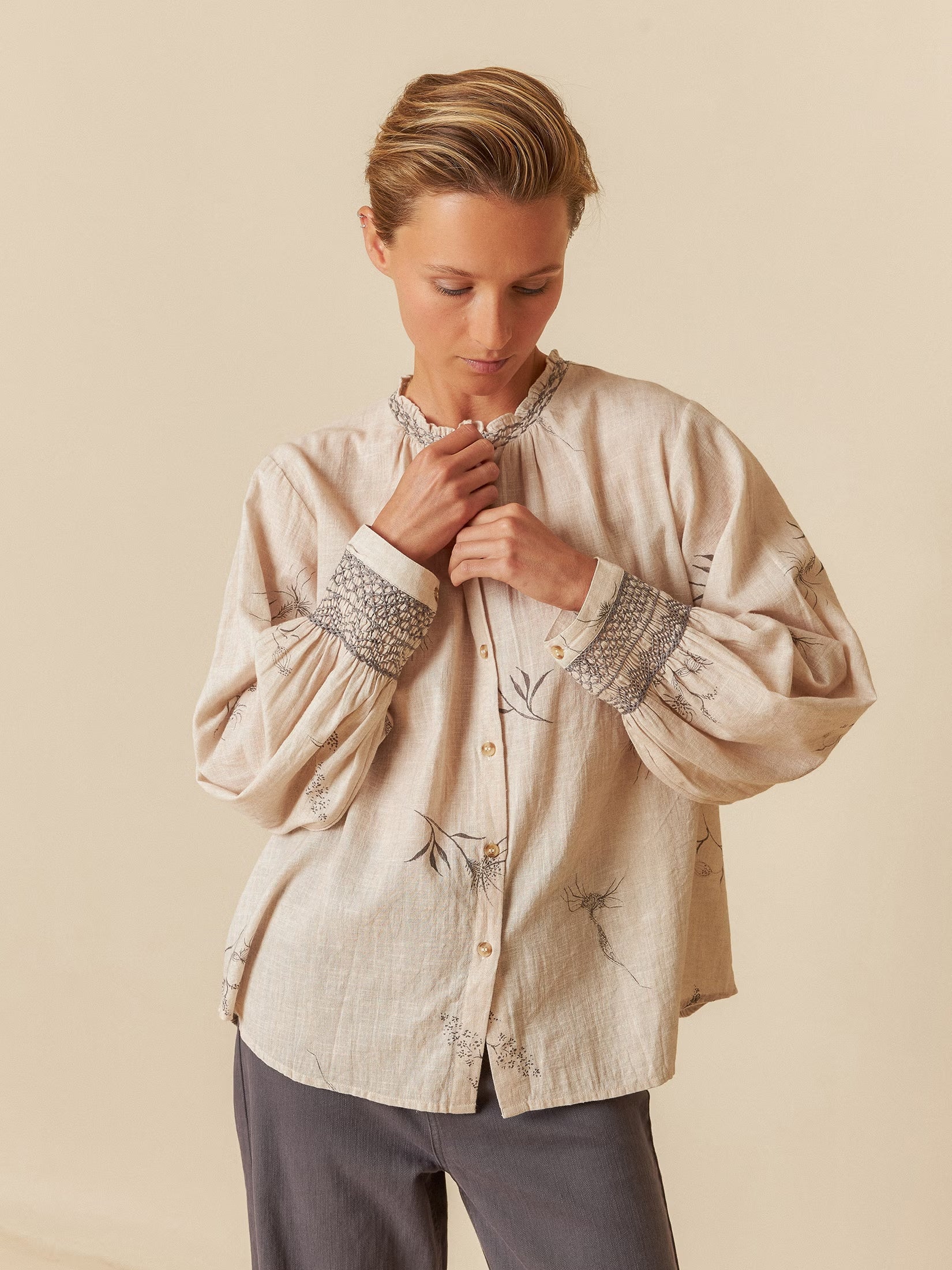 Model wearing a flower-feather print organic cotton shirt with a relaxed fit.