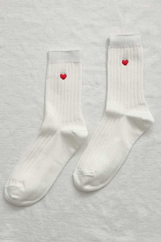 Flat lay picture of pair of socks with a heart.